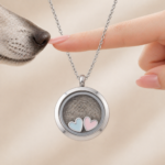 Pet fur keepsake necklace with double heart detail beside a dog's nose